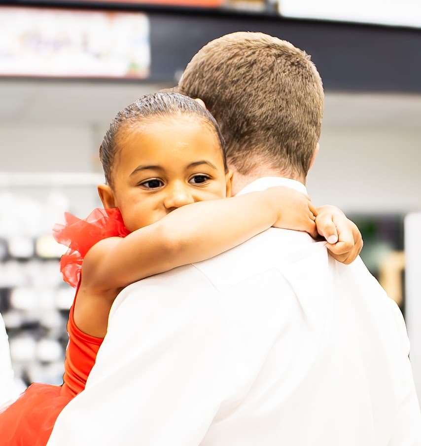 Parent hugging their dancer backstage
